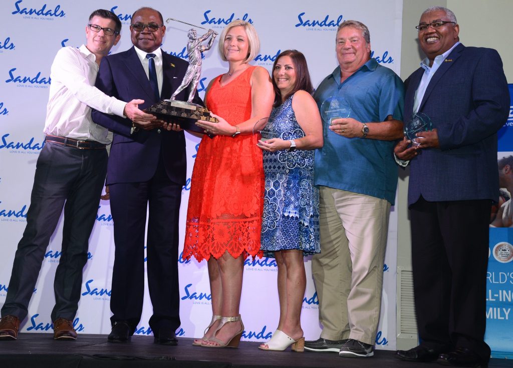 Minister of Tourism, Hon. Edmund Bartlett (2nd left) present the overall team winner’s trophy to VIP travel agents (from left) Mark and Shayla Gerling, Doug and Jeanette Hernick at the Sandals 16th Annual USA Travel Agent Golf Tournament Awards Dinner at Sandals Ochi Beach Resort Saturday night, September 15, 2018. Sharing the occasion is Senior Vice President, Unique Vacations, Gary Sadler (right).