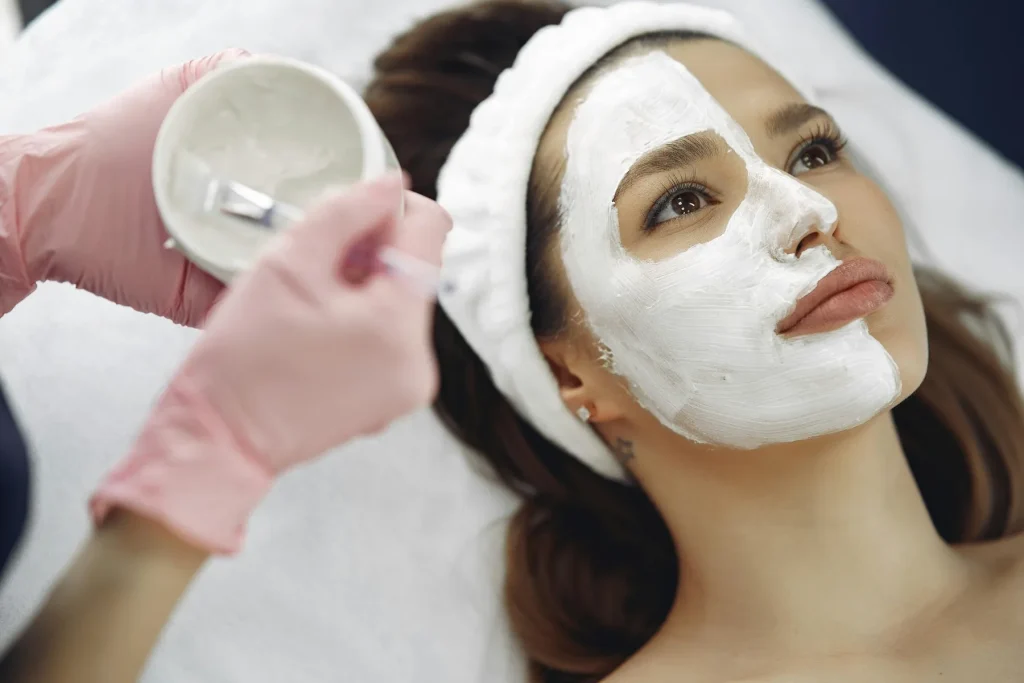 Cosmetologist applying facial mask in luxury spa