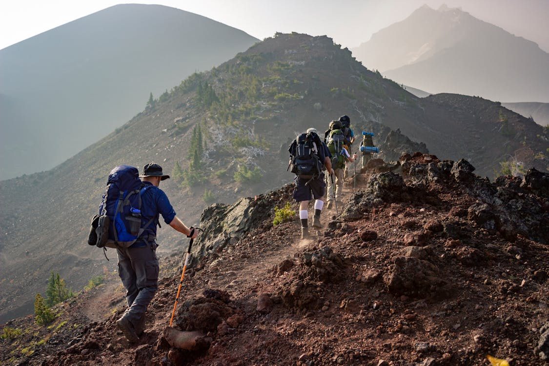 Hiker on dramatic mountain trail at golden hour